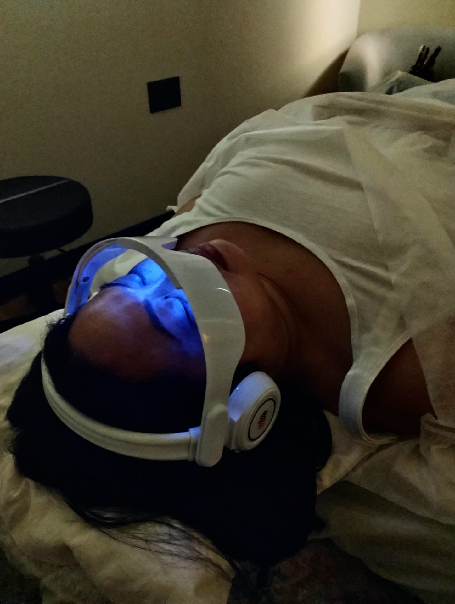 A person relaxing in a chair wearing an audio-visual wellness headset